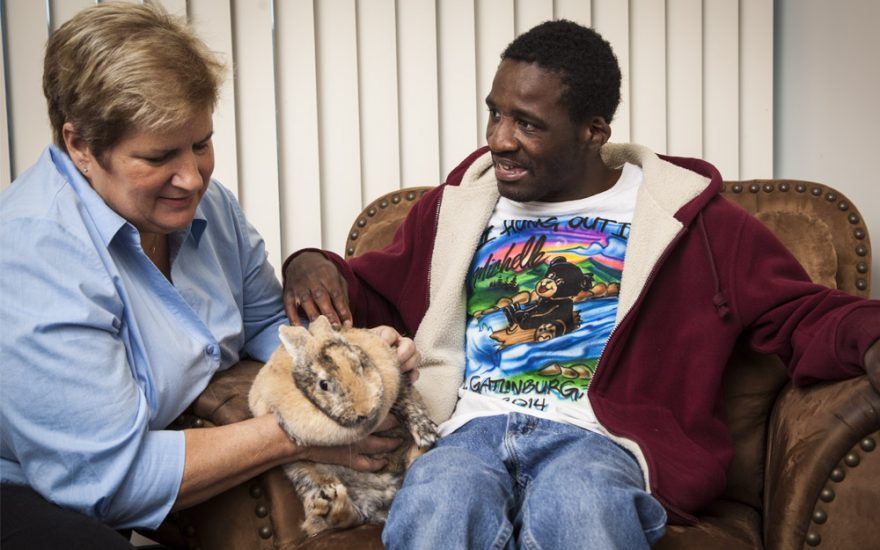 Enhanced Living caregiver holding rabbit with man