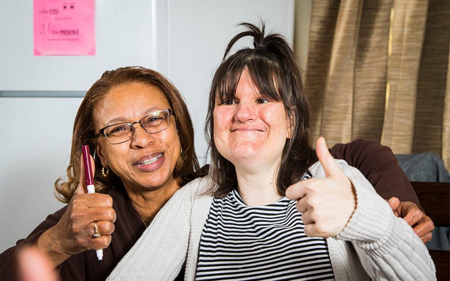 Enhanced Living caregiver and woman giving thumbs up